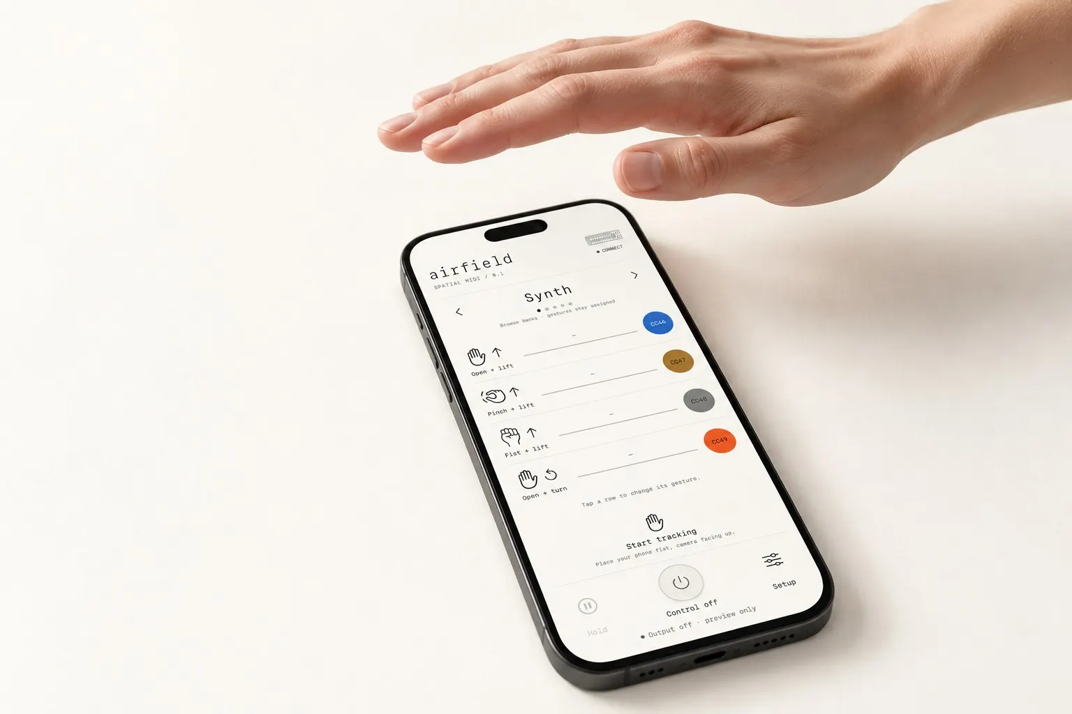 A hand hovering above an iPhone showing AIRFIELD’s four gesture control rows.